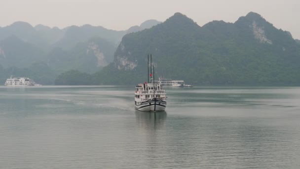 Ship Cruising Halong Bay While Other Boats Anchored Misty Horizon — 图库视频影像
