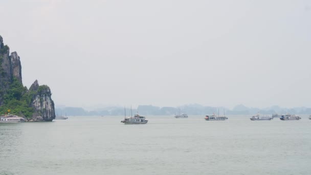 Ship Cruising Halong Bay While Other Boats Anchored Misty Horizon — Vídeos de Stock