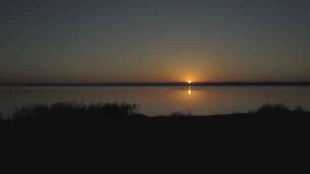 Spectacular Sunset Large Calm Lake Vegetation Silhouette Foreground Downward Forward — Stock video