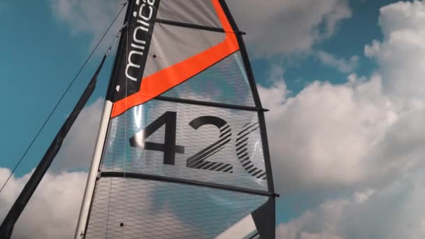 Bright Orange Sail Blowing Wind Camera Pans Right — стоковое видео