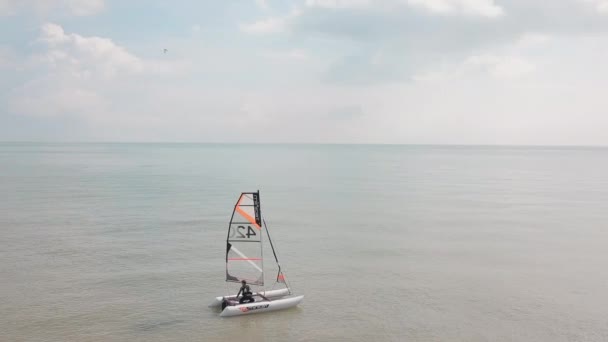 Man Sailing His Catamaran Sea Drone Circles Boat Beautiful Coastal — стоковое видео