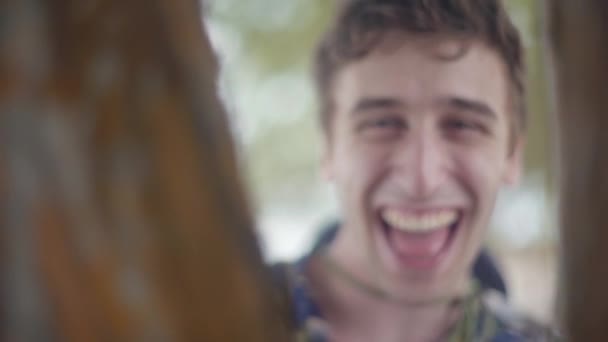 Young Man Laughing Making Silly Faces Camera Tree Branches Teasingly — Stockvideo