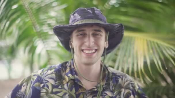 Young Male Explorer Hawaiian Shirt Wide Brim Hat Smiles Camera — Stockvideo