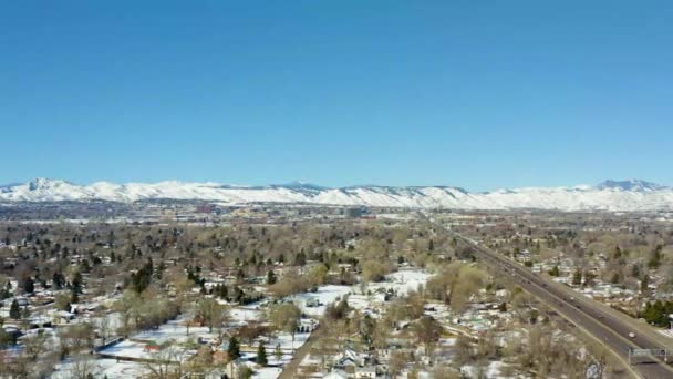 Aerial Side Moving Shot Roads City Overlooking Snowy Mountain Denver — Vídeo de stock