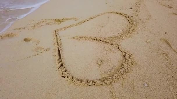Секунд Кадри Піщаного Пляжу Рукою Малює Форму Серця Хвилі Океану — стокове відео
