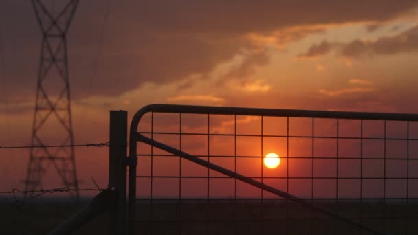 Farm Gate Power Line Pillar Silhouetted Beautiful Orange Sky Static — Video Stock