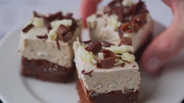 Person Picking Three Chocolate Cream Desserts White Plate Rotation — Video Stock