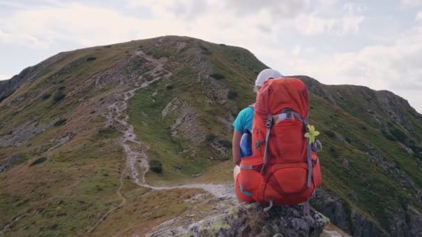 Young Woman Backpacker Sitting Enjoying Mountain Scenery — Stockvideo