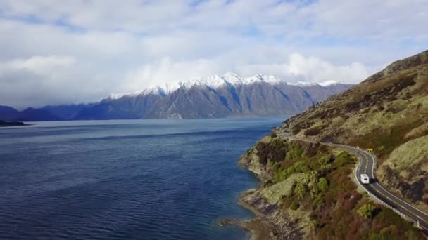 Aerial Tracking Shot New Zealand Driving Coastal Road Snowy Mountains — стокове відео