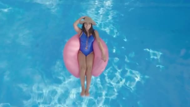 Beautiful Brunette Woman Relaxing Inflatable Pink Ring Swimming Pool Aerial — 비디오