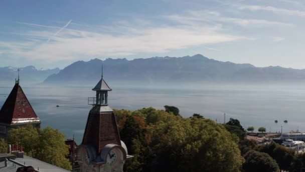 Aerial Clock Tower Overlooking Large Beautiful Lake Mountains Distance — Vídeo de Stock
