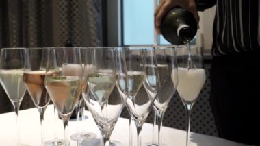 Pouring champagne into glasses - slow motion.Celebrating moments, close up view.