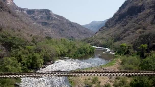 Aerial Drone Flying Away Suspension Bridge Which Crosses River Canyon — Αρχείο Βίντεο