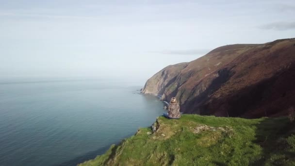 Aerial Panning Drone Shot Woman Sat Cliff Overlooking Coastal View — Stok video