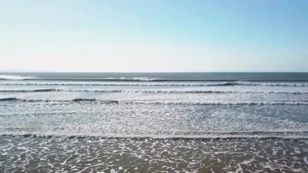 イギリスのサウントン サンズ ビーチで波が海岸を洗う反対側のドローンの移動 低空力 — ストック動画