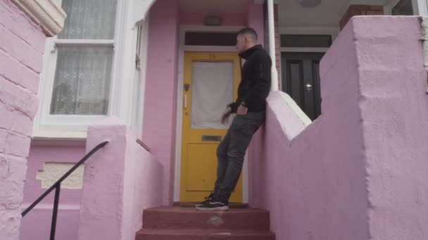 Handsome Caucasian Young Man Waiting Front Yellow Door Pink House — Vídeos de Stock