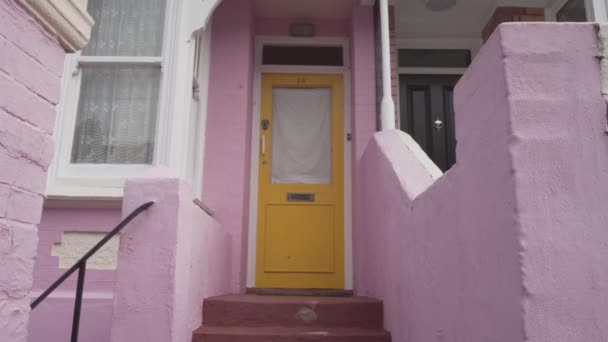 Young Caucasian Handsome Man Knocking Yellow Door Pink House Entrance — Stock video