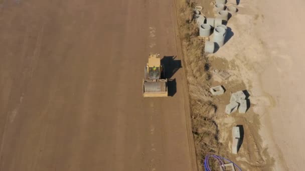 Aerial Shot Bulldozer Roller Compacting Dirt Field Next Drain Pipes — Video