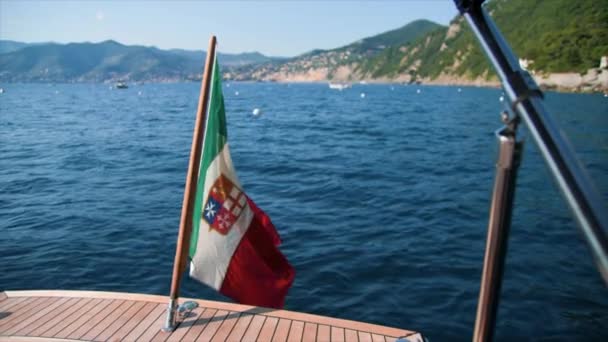 Italian Flag Stern Boat Blurry Background Sea Promontory Mountains Shot — Vídeos de Stock
