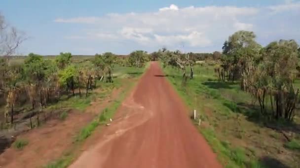 Low Moving Drone Shot Long Straight Red Road Green Bushland — Vídeo de Stock