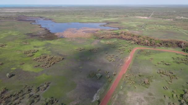 High Slow Moving Drone Shot Red Road Green Bushland Water — ストック動画