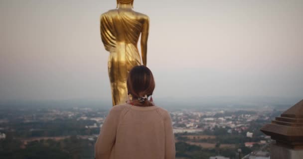 Woman Walks Close Golden Buddha Statue — Stock video