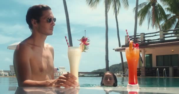 Poolside Men Holding Cocktail Girl Swims Sit Him Bright Sunny — Vídeo de Stock