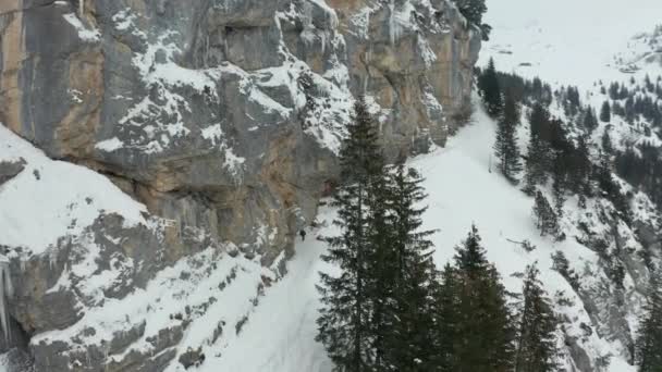 Aerial Hikers Walking Mountain Path Tilting Frozen Mountain Wall — Video