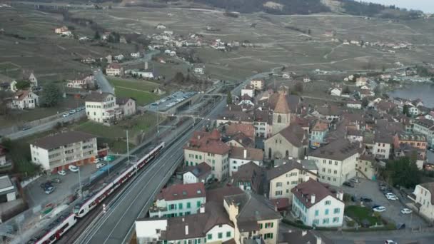 Aerial Train Leaving Idyllic Swiss Town Edge Lake — Stockvideo