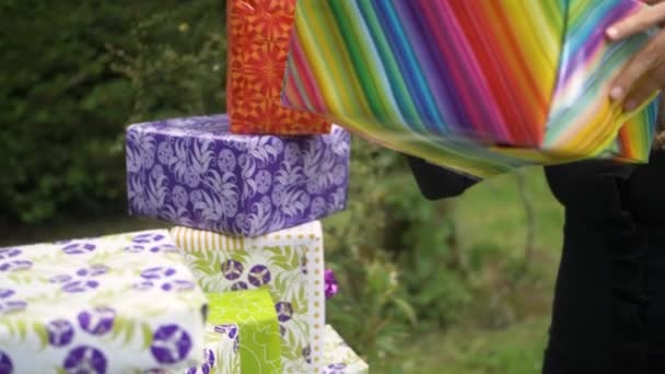 Woman Placing Colorful Wrapped Gift Pile Aniversary Presents Garden Celebration — Stock Video