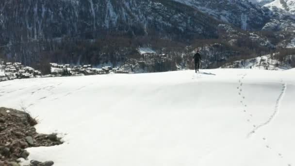 Person Walking Snow Covered Mountain Edge Looking Valley — Video