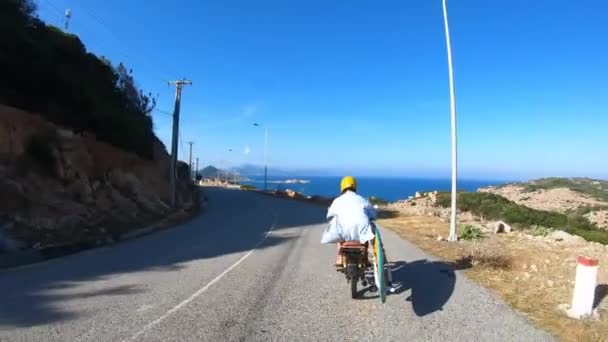 Person Driving Motor Scooter Holding Surfboard Vietnam Tracking Shot — Stockvideo