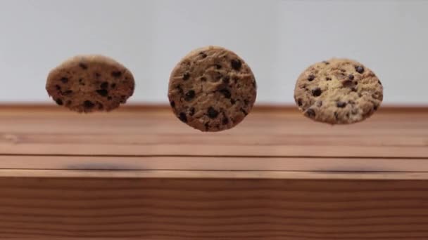 Three Chocolate Chip Cookie Spinning Rolling Air Wooden Table — Vídeo de Stock
