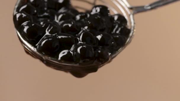 紧贴铁勺与厚重的黑色木瓜珍珠坠落 柔软的背景 — 图库视频影像