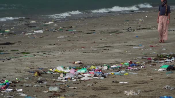 Woman Walking Beach Filled Garbage Washed Sand Static Shot — Vídeos de Stock