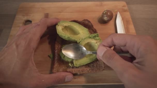 Людина Розбиває Свіжий Авокадо Підсмаженому Хлібі Чайною Ложкою Крупним Планом — стокове відео