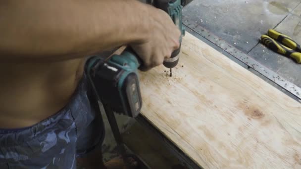 Shirtless Worker Drilling Hole Wooden Board While Making Skateboard — Wideo stockowe