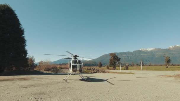 大型空起落架上一架小型私人直升机准备起飞 手持式射击 — 图库视频影像