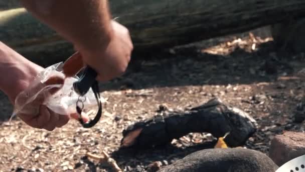 Ένας Άντρας Βάζει Ψητά Λουκάνικα Ένα Τηγάνι Στη Φωτιά — Αρχείο Βίντεο