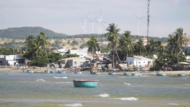 Static Shot Beach Scene Moored Coracle Boat Wind Turbines Background — Vídeo de Stock