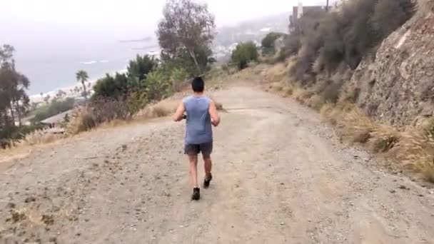 Male Running Dirt Path Coast Backround — Stockvideo