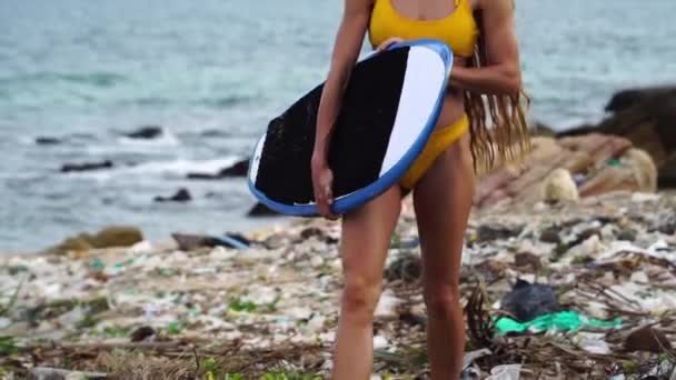 Surfer Dziewczyna Noszenie Bikini Gospodarstwa Deska Surfingowa Chodzenie Oceanie Śmieci — Wideo stockowe