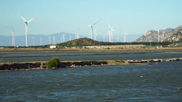 Wind Turbines Spinning Wind Farm River Lake Water Flowing Foreground — Stockvideo