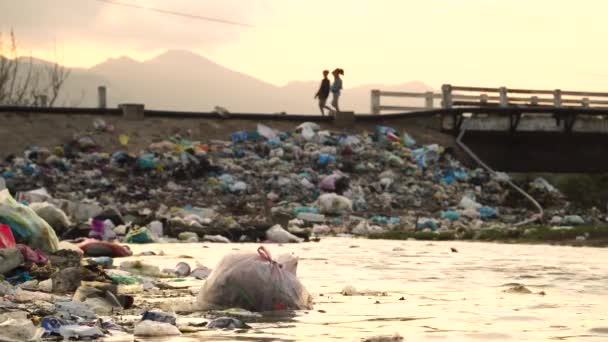 Silueta Personas Caminando Por Puente Con Montones Basura Ladera Lateral — Vídeos de Stock