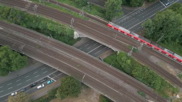 鸟瞰一座铁路桥穿过一条大街时 一辆红色通勤火车穿过桥到北方 2022年6月 德国科隆 — 图库视频影像