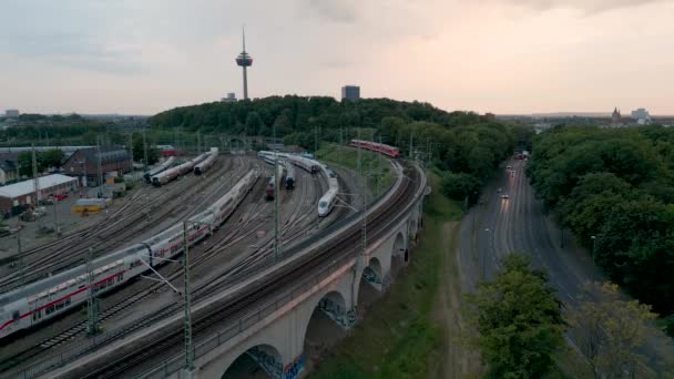 在一个阳光明媚的夜晚 火车站和火车站的院子里可以看到德国科隆的全景 背景是电视塔 院子里有很多火车 — 图库视频影像