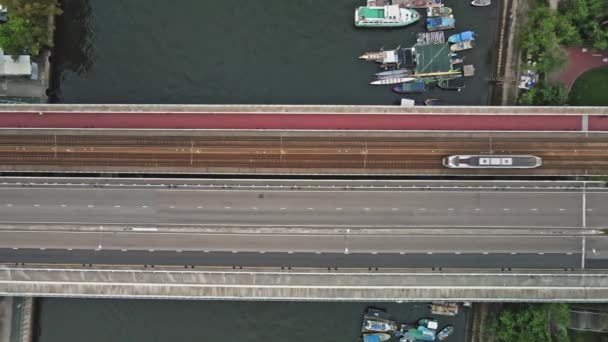 中国の都市の橋を渡るライトレールの空中トップダウンビュー — ストック動画