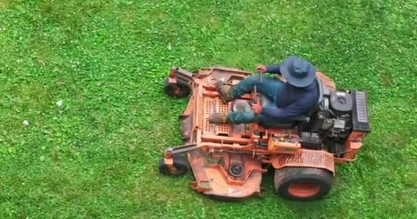 在一个多云的夏日下午 一名园艺师在一家橙色商业割草机上被射中 割草机正在割草 — 图库视频影像