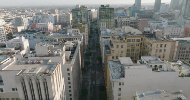 ダウンタウンの街の通りの上を飛ぶドローンロサンゼルスの美しい建物に囲まれた車 — ストック動画