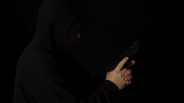 Homem Encapuzado Com Uma Pistola Mão Escuro — Vídeo de Stock